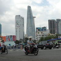 Traffic in Saigon with the Bitexco Financial Tower in the background.